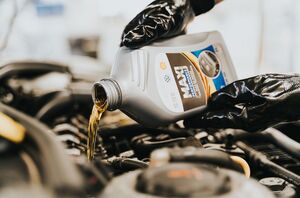 Pouring fresh engine oil during a service